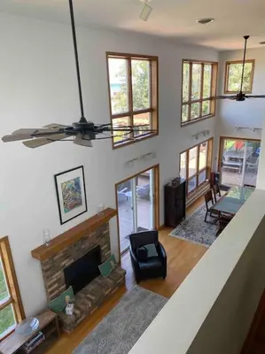 a living room with a fireplace and a chair at Lakeside resort home. Sunsets, fishing, paddling. in Avon Lake