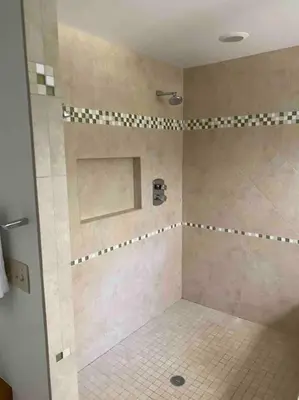 a bathroom with a shower with a tiled floor at Lakeside resort home. Sunsets, fishing, paddling. in Avon Lake