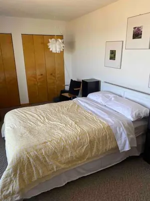 a bedroom with a large bed and two chairs at Lakeside resort home. Sunsets, fishing, paddling. in Avon Lake