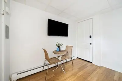 a room with a table and chairs and a tv at Comfy 1BR with Parking - Near UC, Zoo, Downtown in Cincinnati