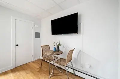 a room with a table and chairs and a tv on the wall at Comfy 1BR with Parking - Near UC, Zoo, Downtown in Cincinnati