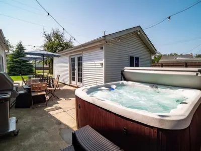 a large hot tub in a yard with a patio at Family Fun: Comfy Home, 10 Min to Cedar Point Fun! in Huron