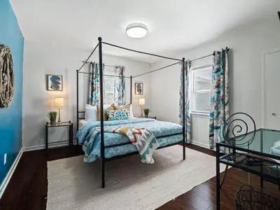 a bedroom with a canopy bed with blue sheets at Family Fun: Comfy Home, 10 Min to Cedar Point Fun! in Huron