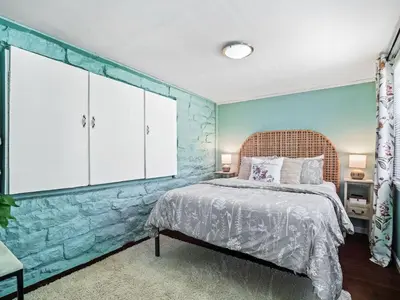 a bedroom with a bed and a stone wall at Family Fun: Comfy Home, 10 Min to Cedar Point Fun! in Huron