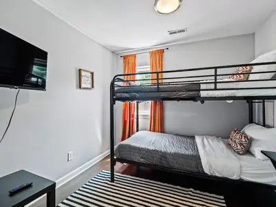 a bedroom with two bunk beds and a flat screen tv at Family Fun: Comfy Home, 10 Min to Cedar Point Fun! in Huron