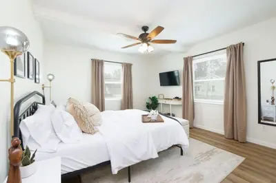 a white bedroom with a bed and a ceiling fan at Port Clinton Getaway Near the Beach in Port Clinton