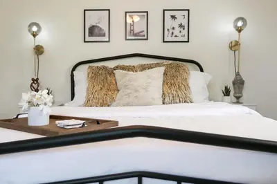 a bedroom with a white bed with a wooden table at Port Clinton Getaway Near the Beach in Port Clinton