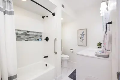 a white bathroom with a toilet and a sink at Port Clinton Getaway Near the Beach in Port Clinton