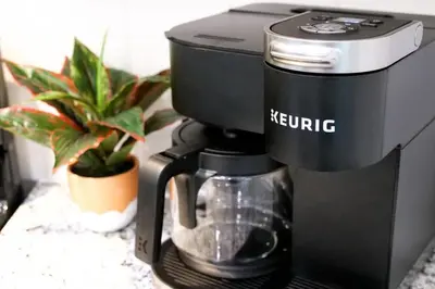 a black coffee maker sitting on a table with a plant at Modern 3BR home next to park, office space, & more in University Heights