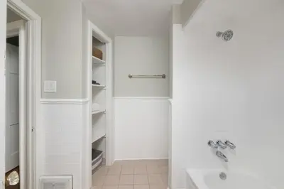 a white bathroom with a shower and a sink at Modern 3BR home next to park, office space, & more in University Heights