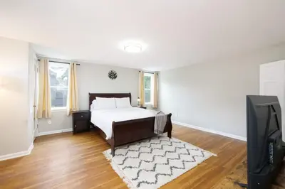 a bedroom with a bed and a flat screen tv at Modern 3BR home next to park, office space, & more in University Heights