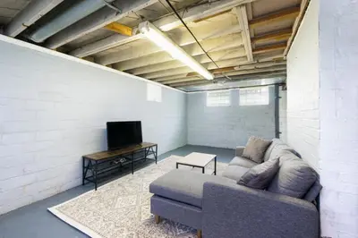 a living room with a couch and a tv at Modern 3BR home next to park, office space, & more in University Heights
