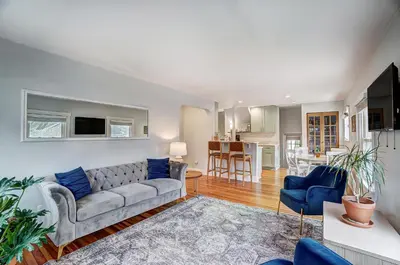 a living room with a couch and a kitchen at The Meeker House (Charming 3/4 Bedroom Home) in Bowling Green