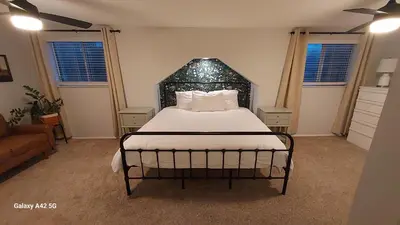 a bedroom with a bed with a black headboard at The Meeker House (Charming 3/4 Bedroom Home) in Bowling Green