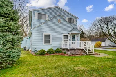 a blue house with a white porch and a yard at The Meeker House (Charming 3/4 Bedroom Home) in Bowling Green