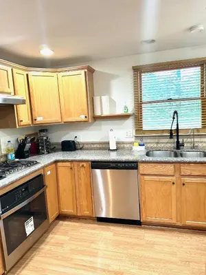 a kitchen with wooden cabinets and a stainless steel dishwasher at Home in Hudson in Hudson