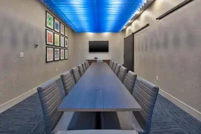 a long conference room with a long table and a tv at Holiday Inn Express & Suites - Milan - Sandusky Area by IHG in Milan