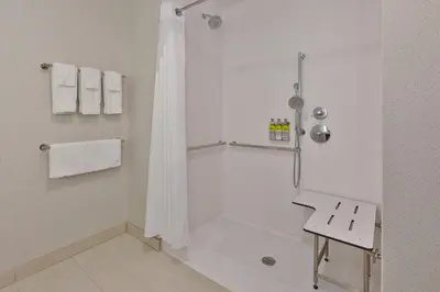 a white bathroom with a shower and a sink at Holiday Inn Express & Suites - Milan - Sandusky Area by IHG in Milan