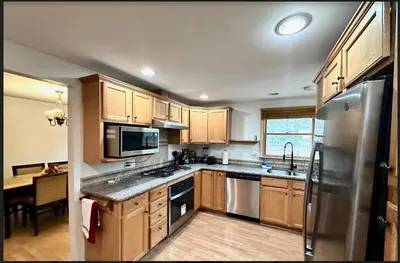 a kitchen with wooden cabinets and a stainless steel refrigerator at Home in Hudson in Hudson