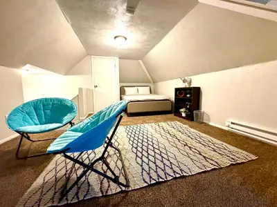 a room with a blue chair and a bed at The House Hotel Elmwood in Lakewood