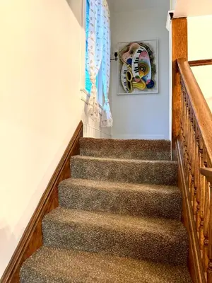 a flight of stairs with a painting on the wall at The House Hotel Elmwood in Lakewood