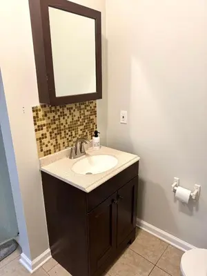 a bathroom with a sink and a mirror at The House Hotel Elmwood in Lakewood
