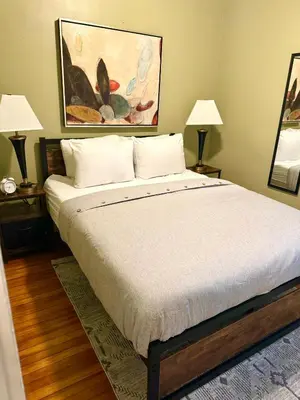 a bedroom with a large bed with two lamps at The House Hotel Elmwood in Lakewood
