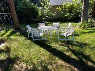 a table and chairs sitting in the grass at Exclusive Ottawa Hills Private Home, Garage, WD, Gourmet Equipped kitchen, Netflix in Ottawa Hills