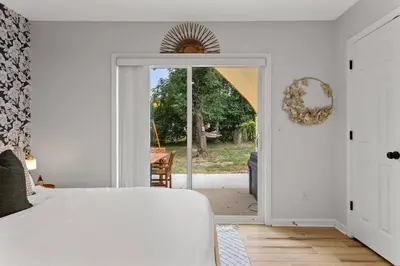 a bedroom with a bed and a door to a yard at The Luxe/HotTub/Playground/12min KHP/30min Ark in Georgetown
