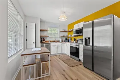 a kitchen with white cabinets and a stainless steel refrigerator at The Luxe/HotTub/Playground/12min KHP/30min Ark in Georgetown