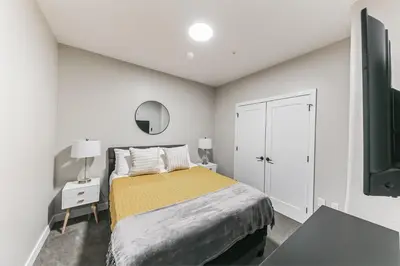 a white bedroom with a bed and a tv at Downtown/Bengals/Reds/TQL/OTR in Cincinnati
