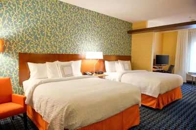 a hotel room with two beds and a chair at Fairfield Inn and Suites Canton South in Canton