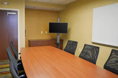 a conference room with a table and chairs and a flat screen tv at Fairfield Inn and Suites Canton South in Canton
