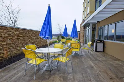 a group of tables and chairs with blue umbrellas at Fairfield Inn and Suites Canton South in Canton