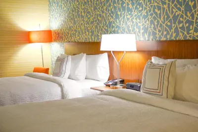 two beds in a hotel room with two lamps at Fairfield Inn and Suites Canton South in Canton