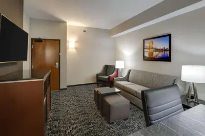 a hotel room with a couch and a flat screen tv at Drury Plaza Hotel Cincinnati Florence in Florence