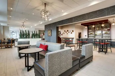 a restaurant with tables and chairs and a bar at Drury Plaza Hotel Cincinnati Florence in Florence