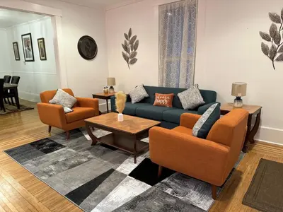 a living room with a blue couch and orange chairs at Beautiful Bungalow on Main in Madison