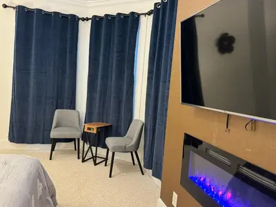 a bedroom with a tv and two chairs and a table at Beautiful Bungalow on Main in Madison