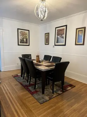a dining room table with black chairs and a chandelier at Beautiful Bungalow on Main in Madison