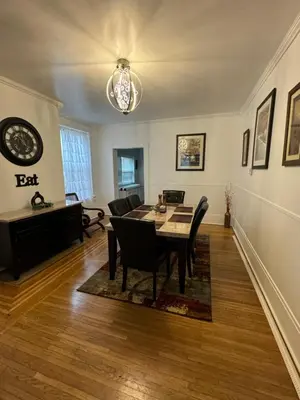 a dining room with a table and chairs and a clock at Beautiful Bungalow on Main in Madison