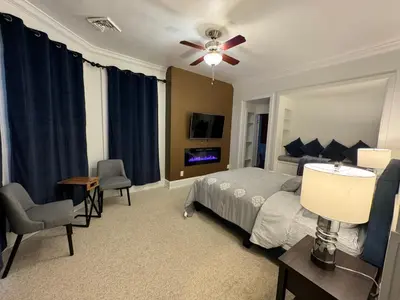 a bedroom with a bed and a table and chairs at Beautiful Bungalow on Main in Madison