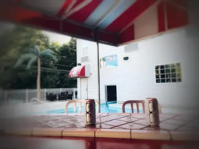 a table with two chairs in front of a pool at Bay Lodging Resort in Put-in-Bay