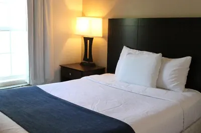 a bedroom with a large white bed with a black headboard at Bay Lodging Resort in Put-in-Bay