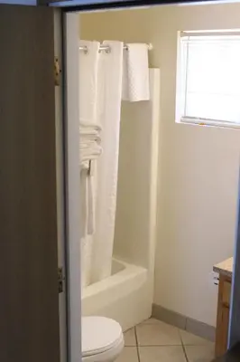 a bathroom with a toilet and a bath tub with towels at Bay Lodging Resort in Put-in-Bay