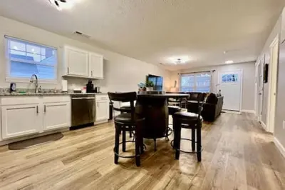 a kitchen with white cabinets and a table and stools at Nicest New construction Home in Middletown, Ohio in Middletown