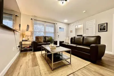 a living room with a leather couch and a table at Nicest New construction Home in Middletown, Ohio in Middletown