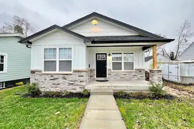 a white house with a black door in a yard at Nicest New construction Home in Middletown, Ohio in Middletown