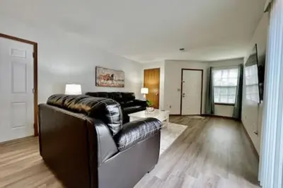 a living room with a leather couch and a table at Charming remodeled 2 bed GEM Middletown in Middletown