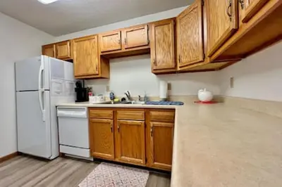 a kitchen with wooden cabinets and a white refrigerator at Charming remodeled 2 bed GEM Middletown in Middletown